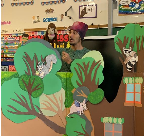 Puppeteers performing a puppet show on a forest stage set