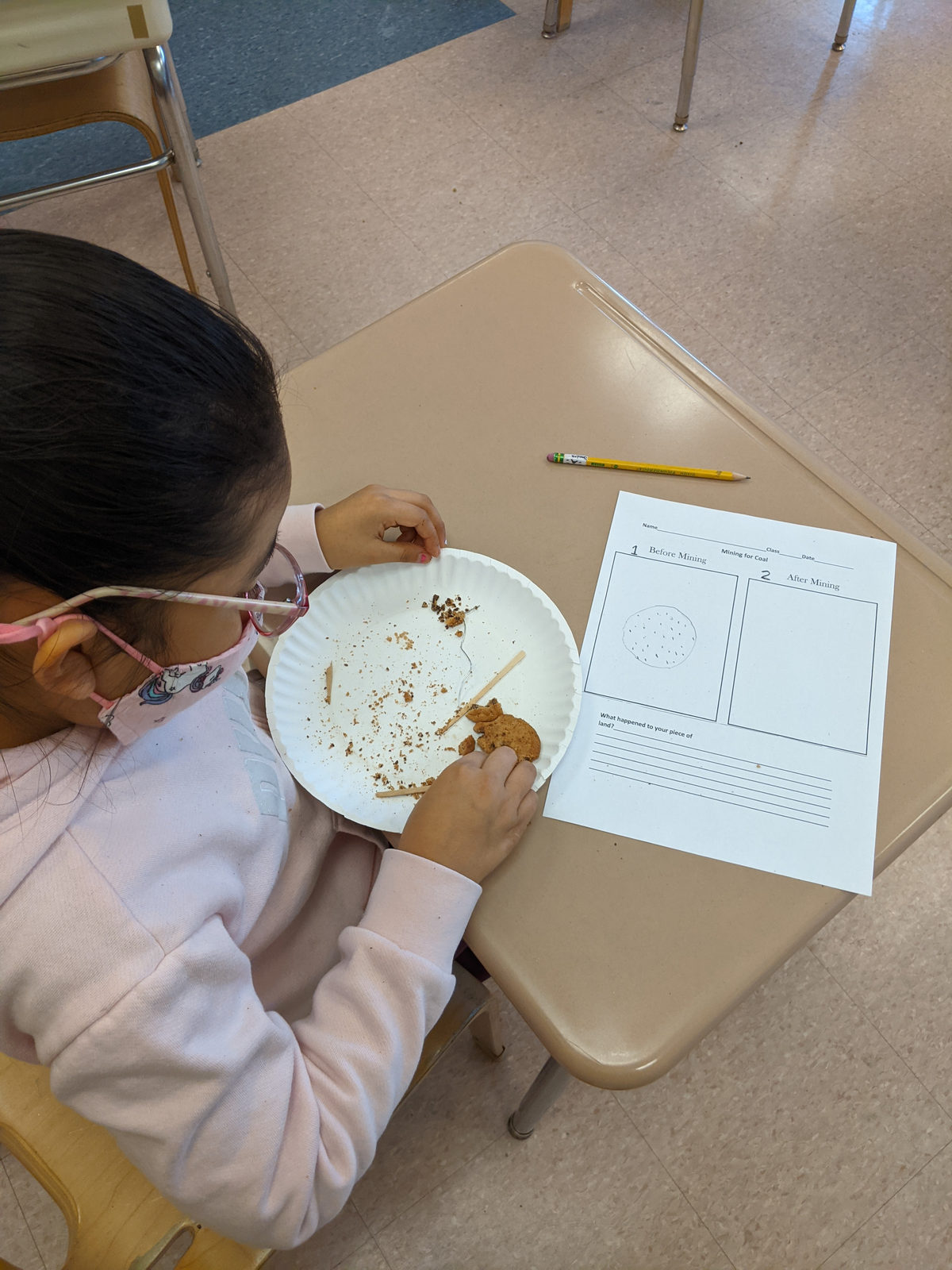 A student recording observations on a worksheet during a science activity