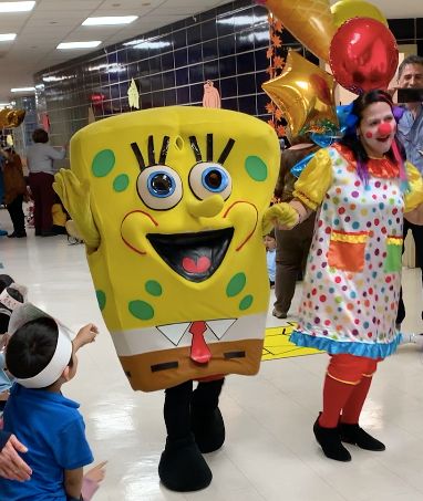 SpongeBob and a clown visiting students at a school celebration