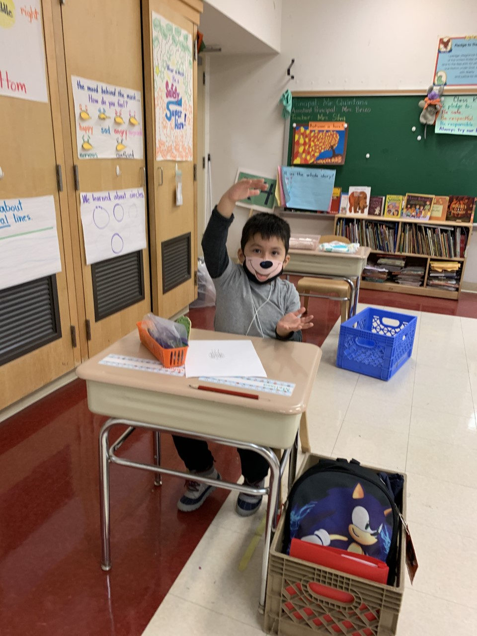 Student raising his hand at his desk