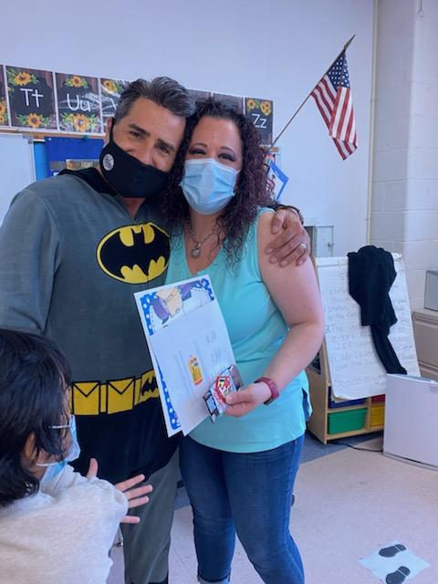 Principal in a Batman costume with a teacher holding a certificate