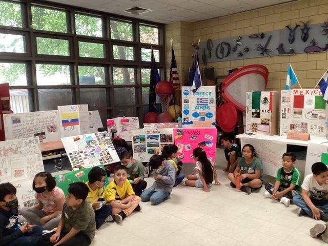 Students seated in front of flags and country project boards