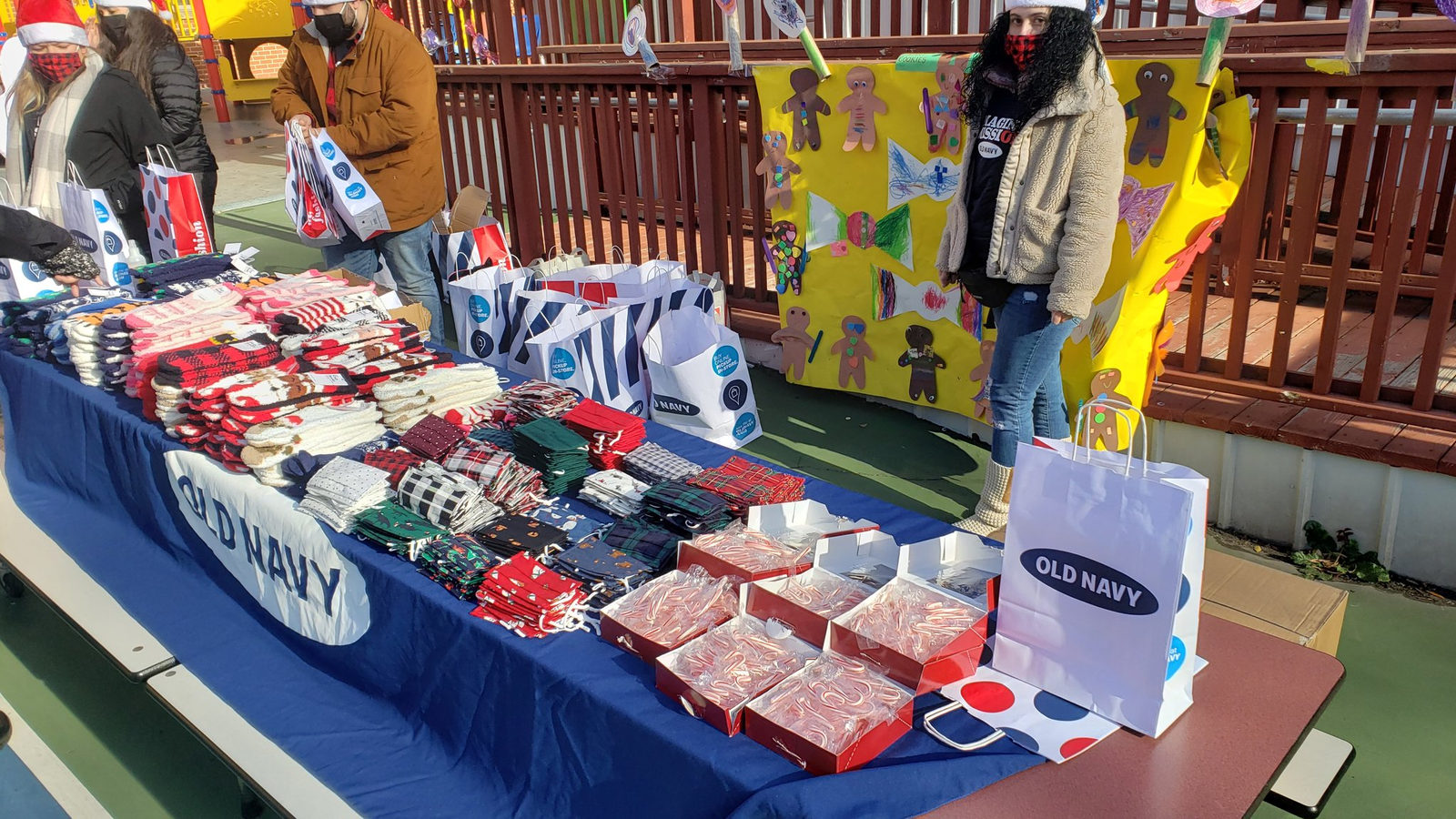Old Navy table stacked with holiday clothing gifts