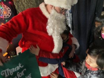 Santa handing a gift bag to a student