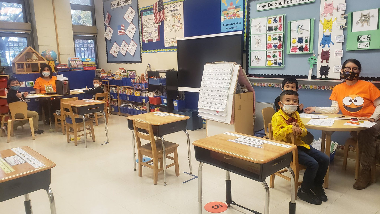 Students in Halloween costumes at spaced-out desks
