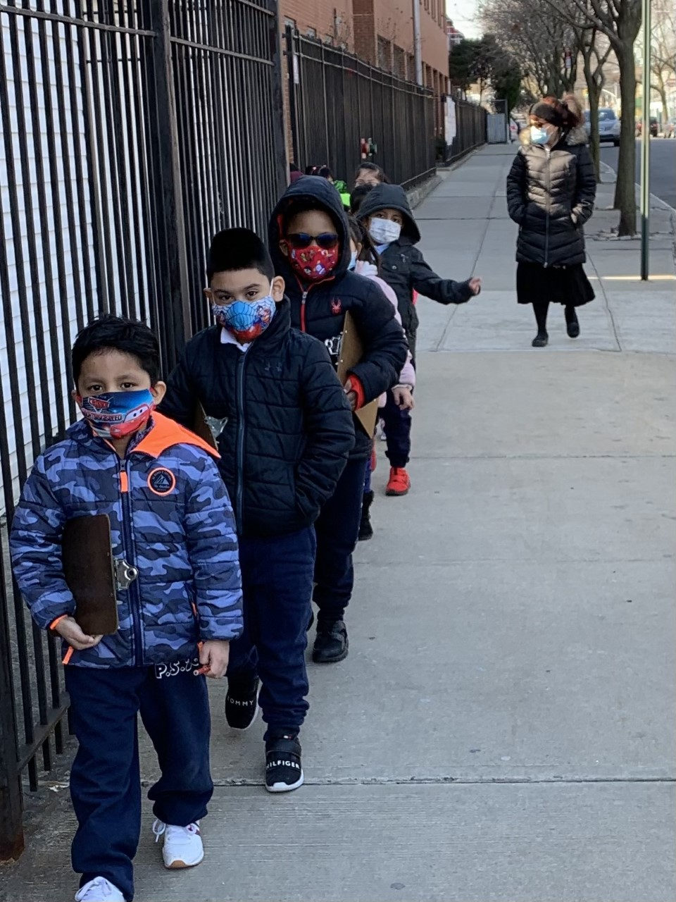 Students carrying clipboards on a neighborhood walk