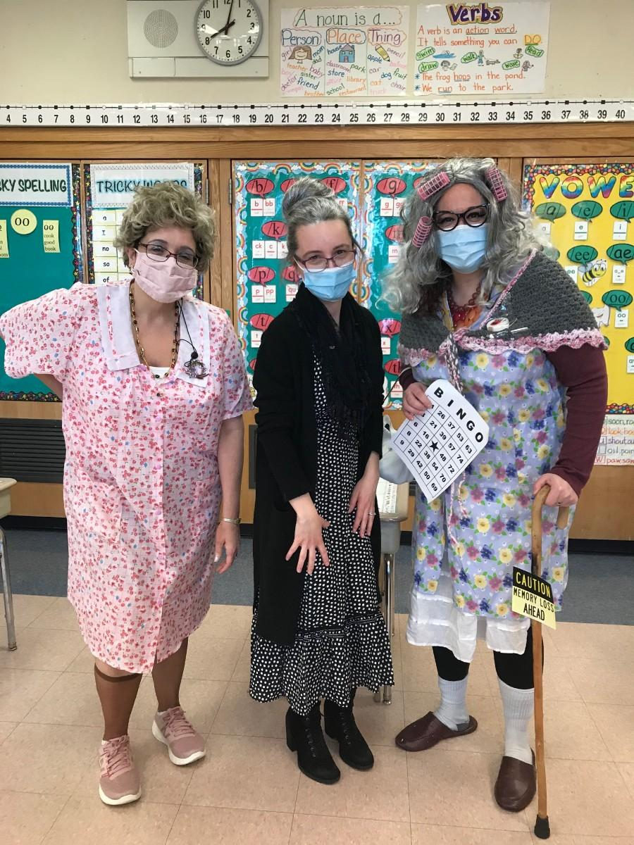 Three staff members dressed as grandparents in a classroom