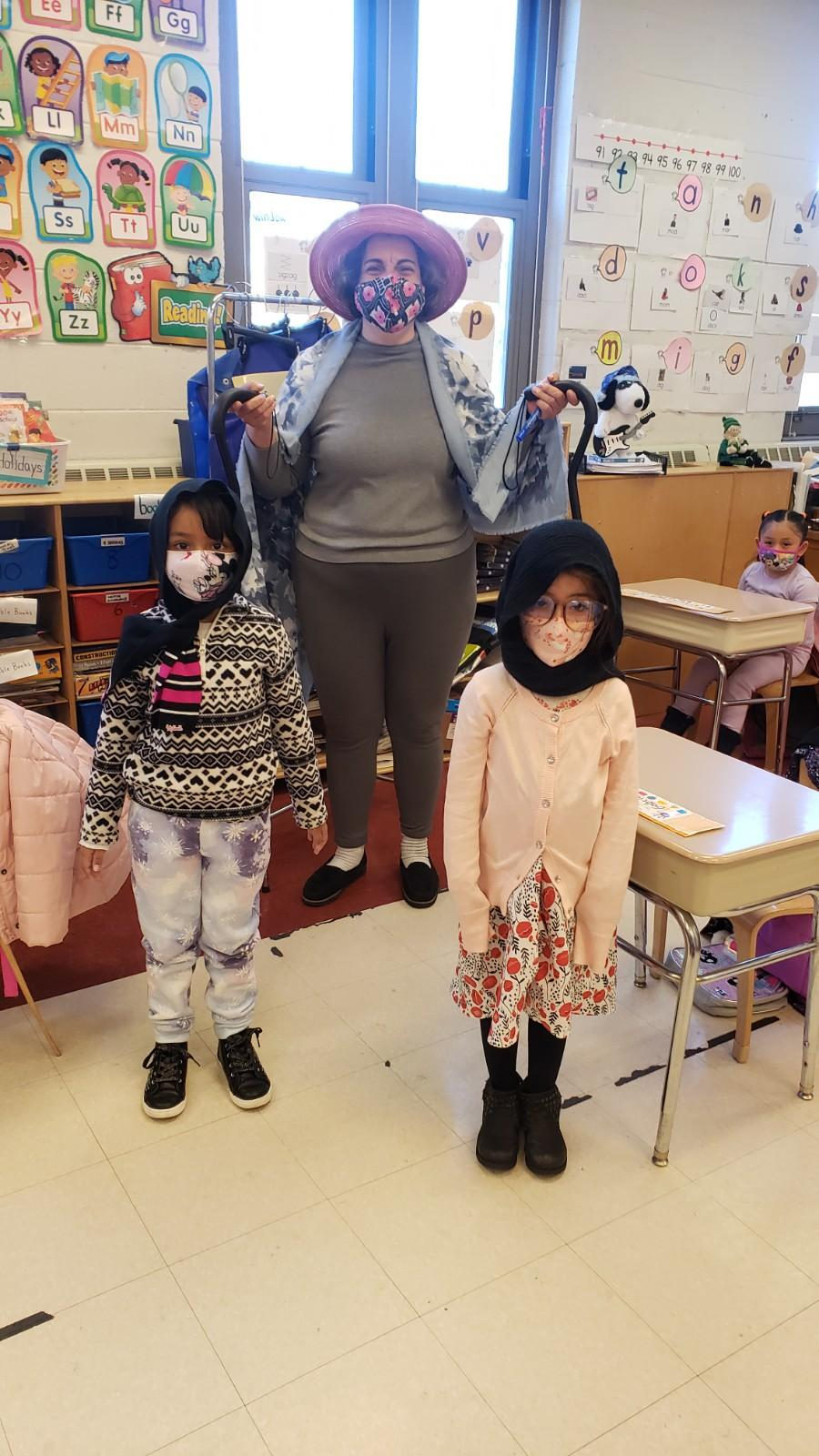 Teacher dressed as a grandmother with two students