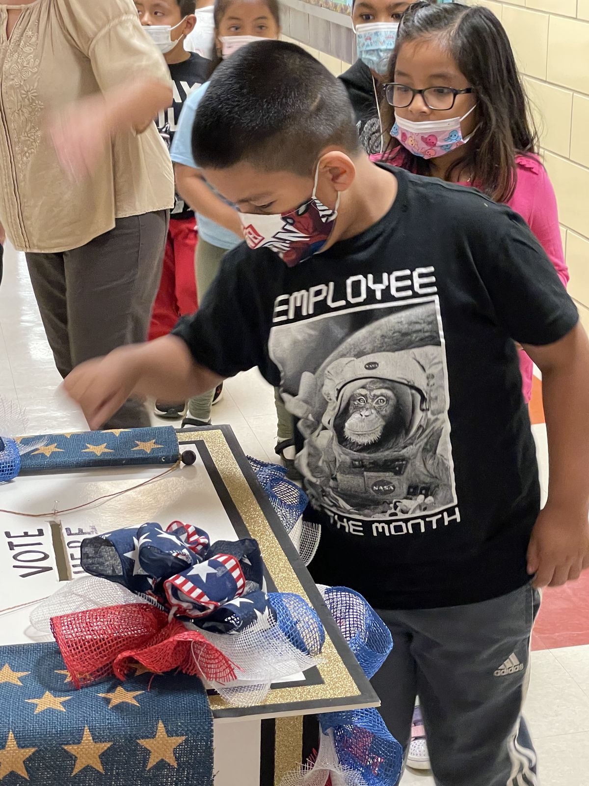 Student casting a ballot at the decorated box