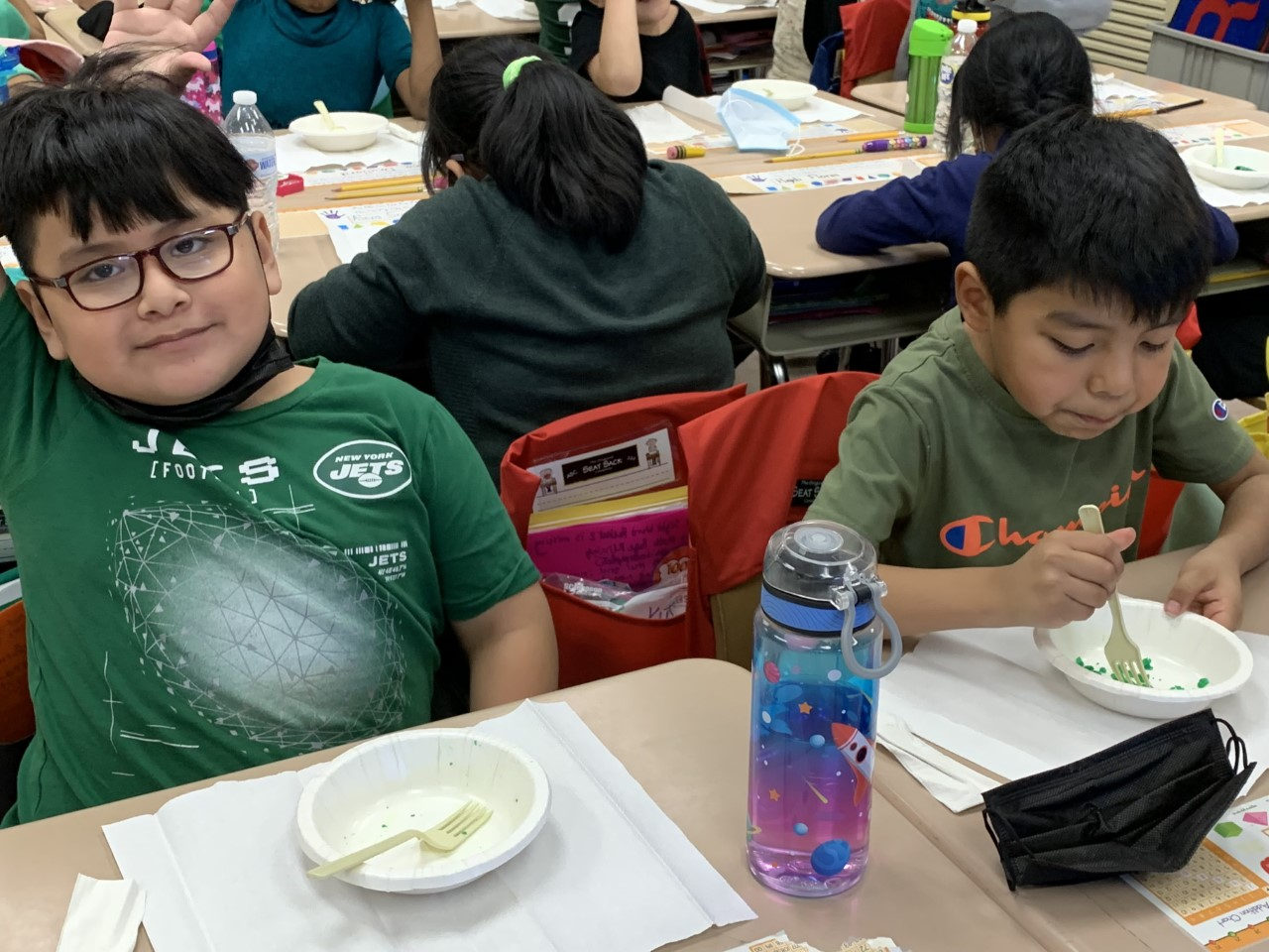 Students in green shirts eating green eggs