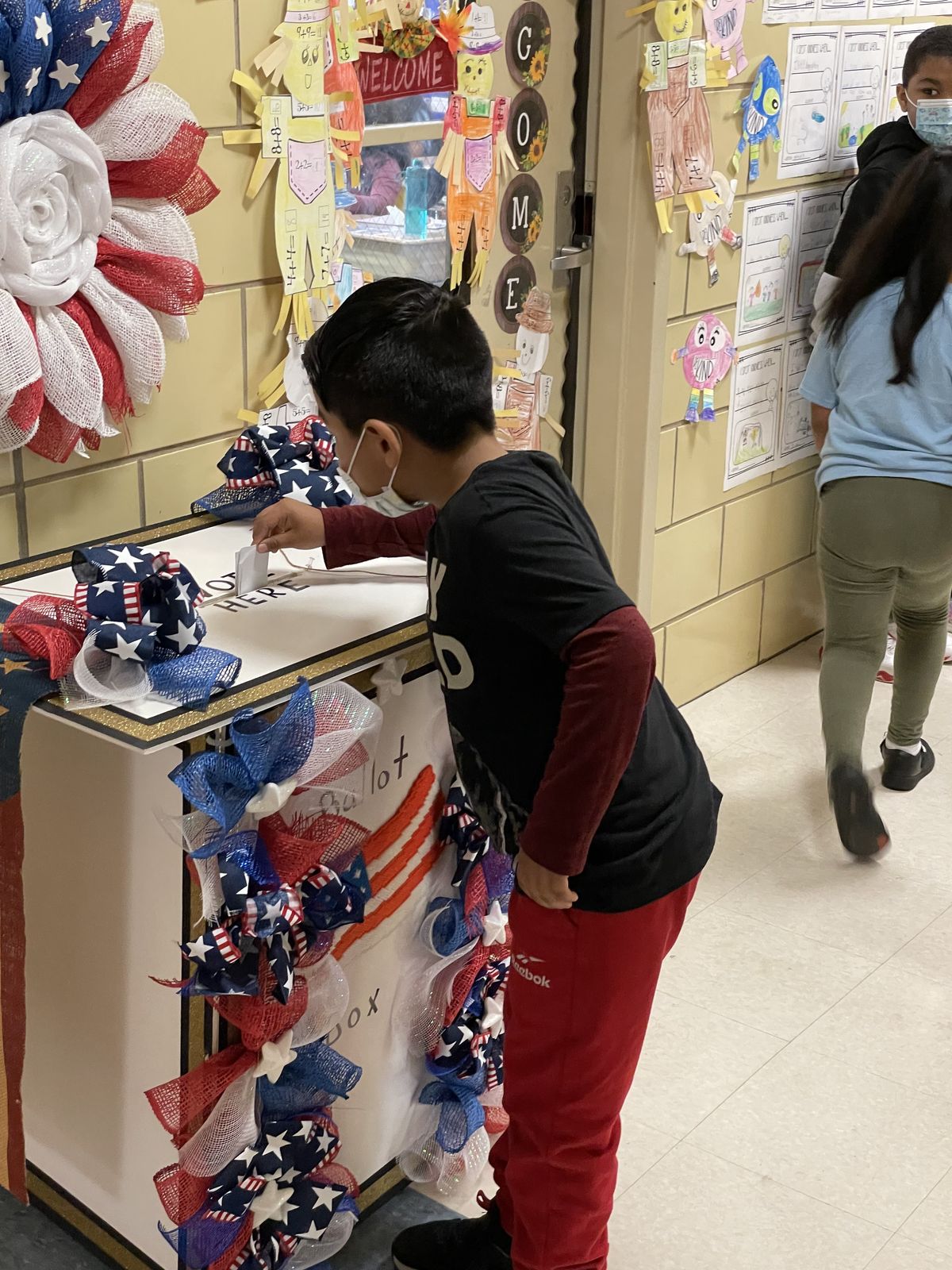 Student dropping a ballot into the ballot box