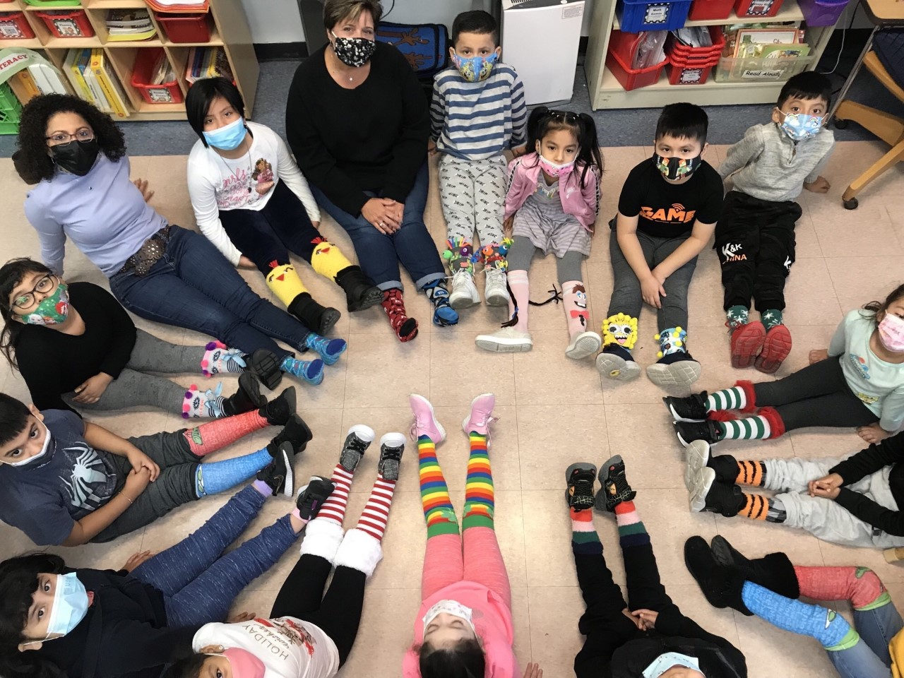 Students lying on the floor in a circle to show off their crazy socks