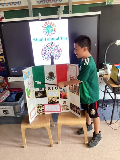Student in a Mexico jersey presenting a Mexico trifold board