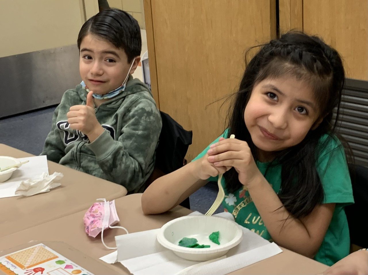Two students giving a thumbs up while eating green eggs