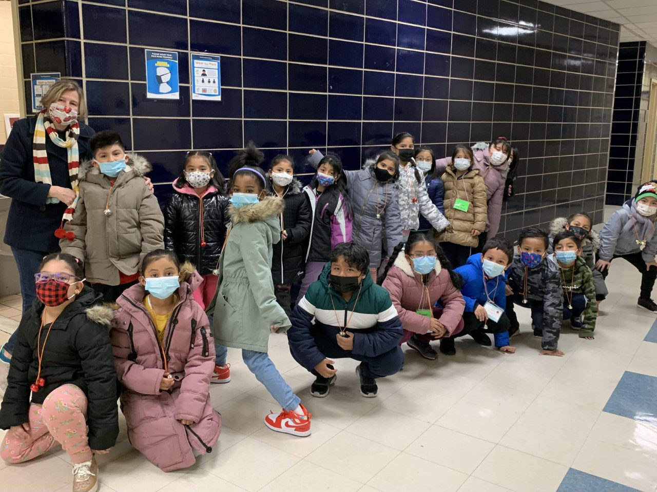 Class posing in the hallway in winter coats