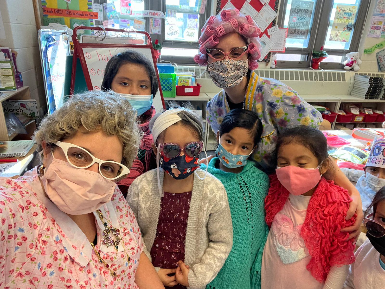 Staff member dressed as a grandmother posing with students