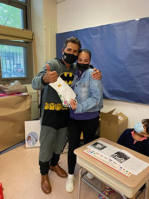 Principal in a Batman costume with a staff member in an office