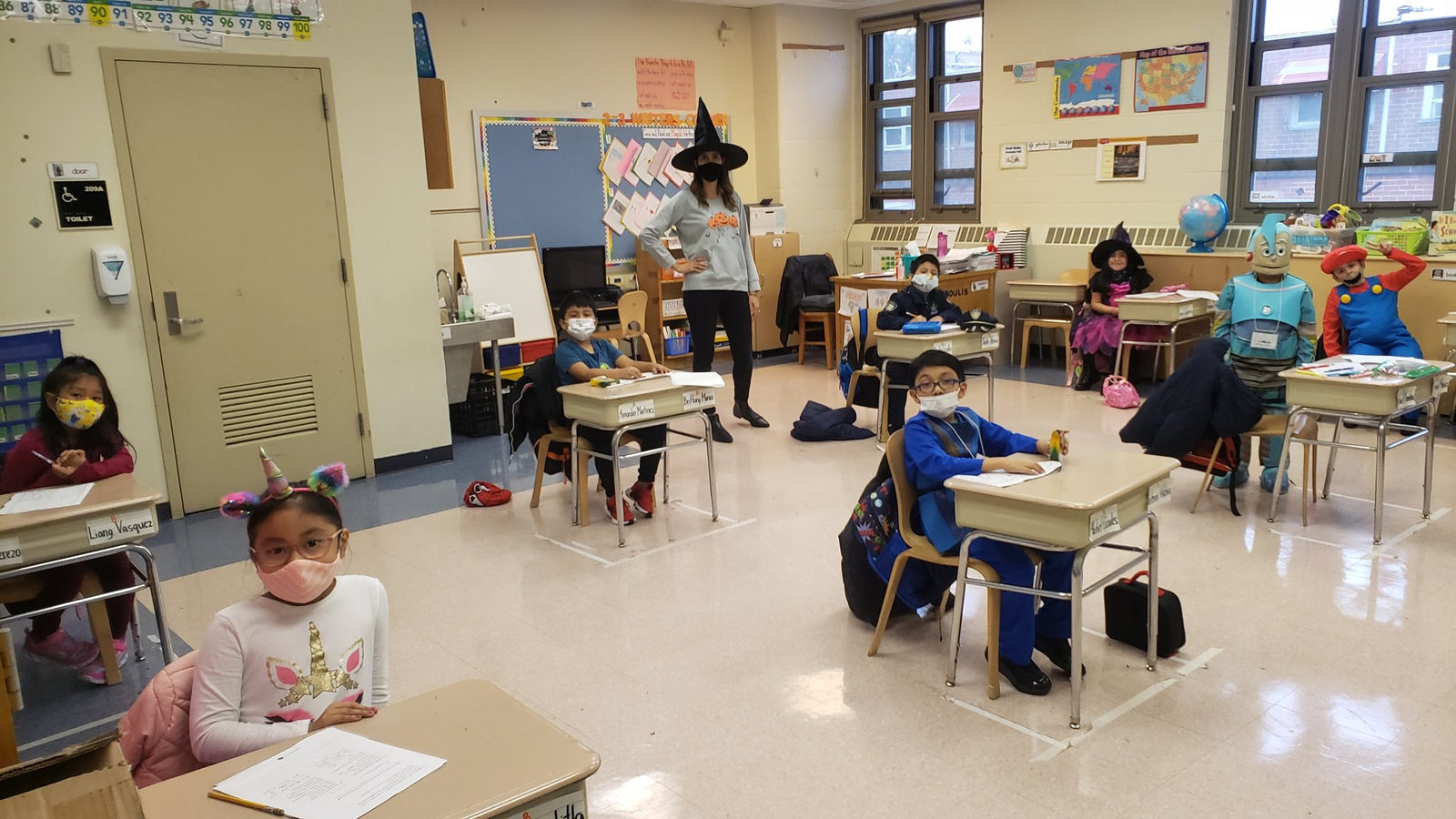Class in Halloween costumes at their desks