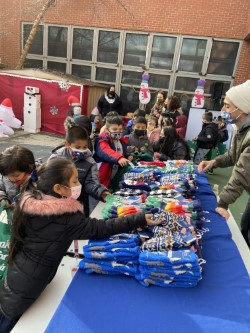 Students choosing gifts from a table outside the school