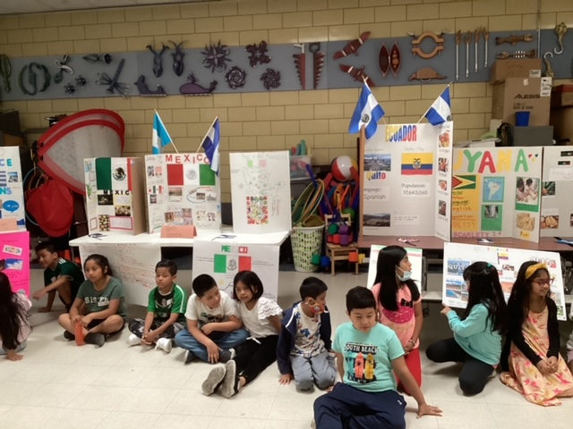 Students sitting in front of the Multicultural Festival displays