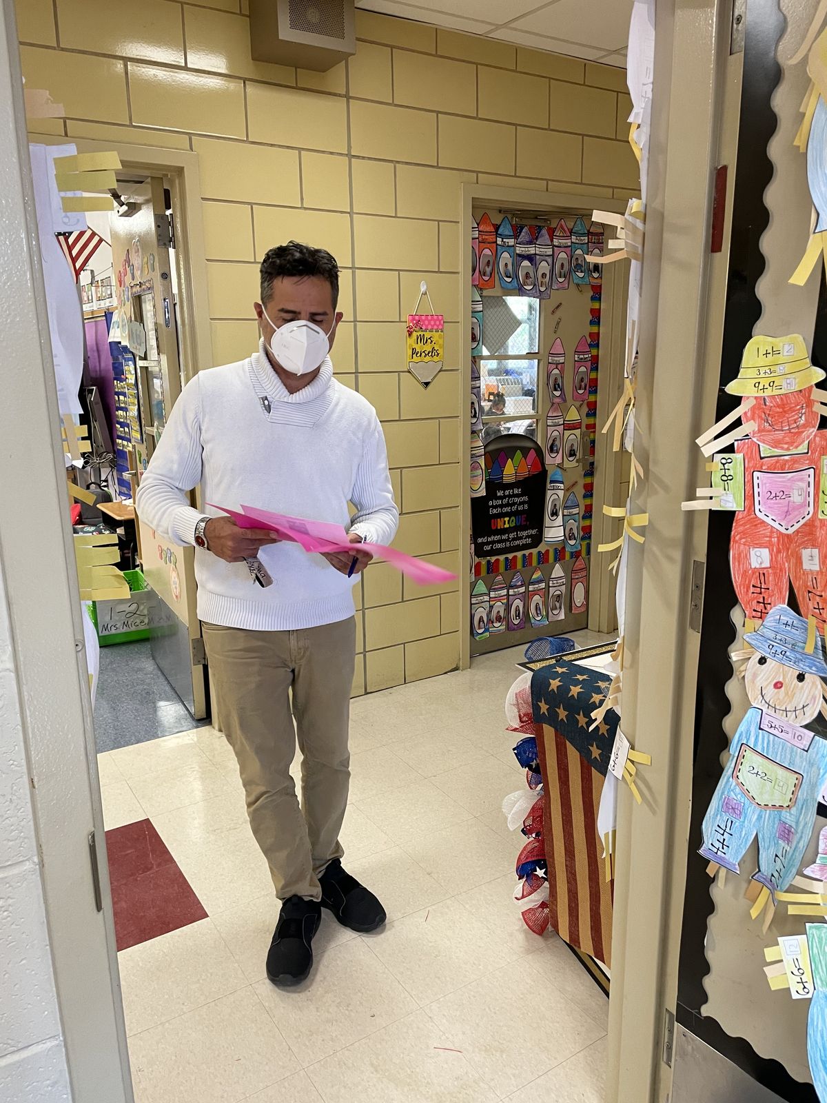 Staff member walking down the hallway carrying a ballot