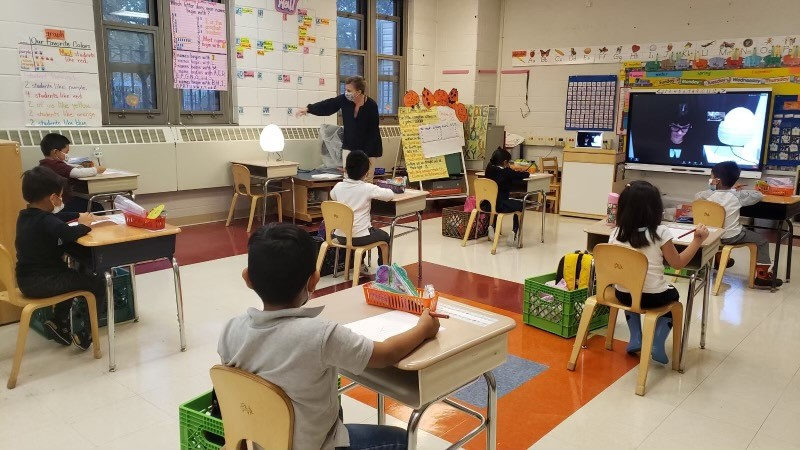 Students working at spaced-out desks in the classroom