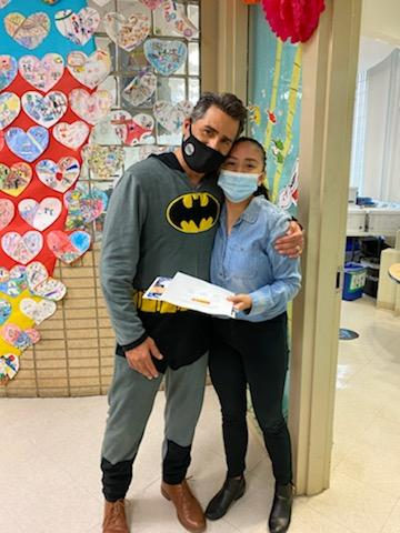 Principal in a Batman costume with a teacher in her classroom doorway