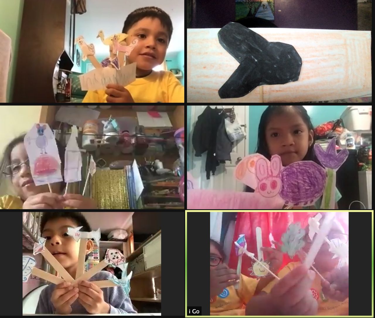 Screenshot of students holding up crafts on a video call