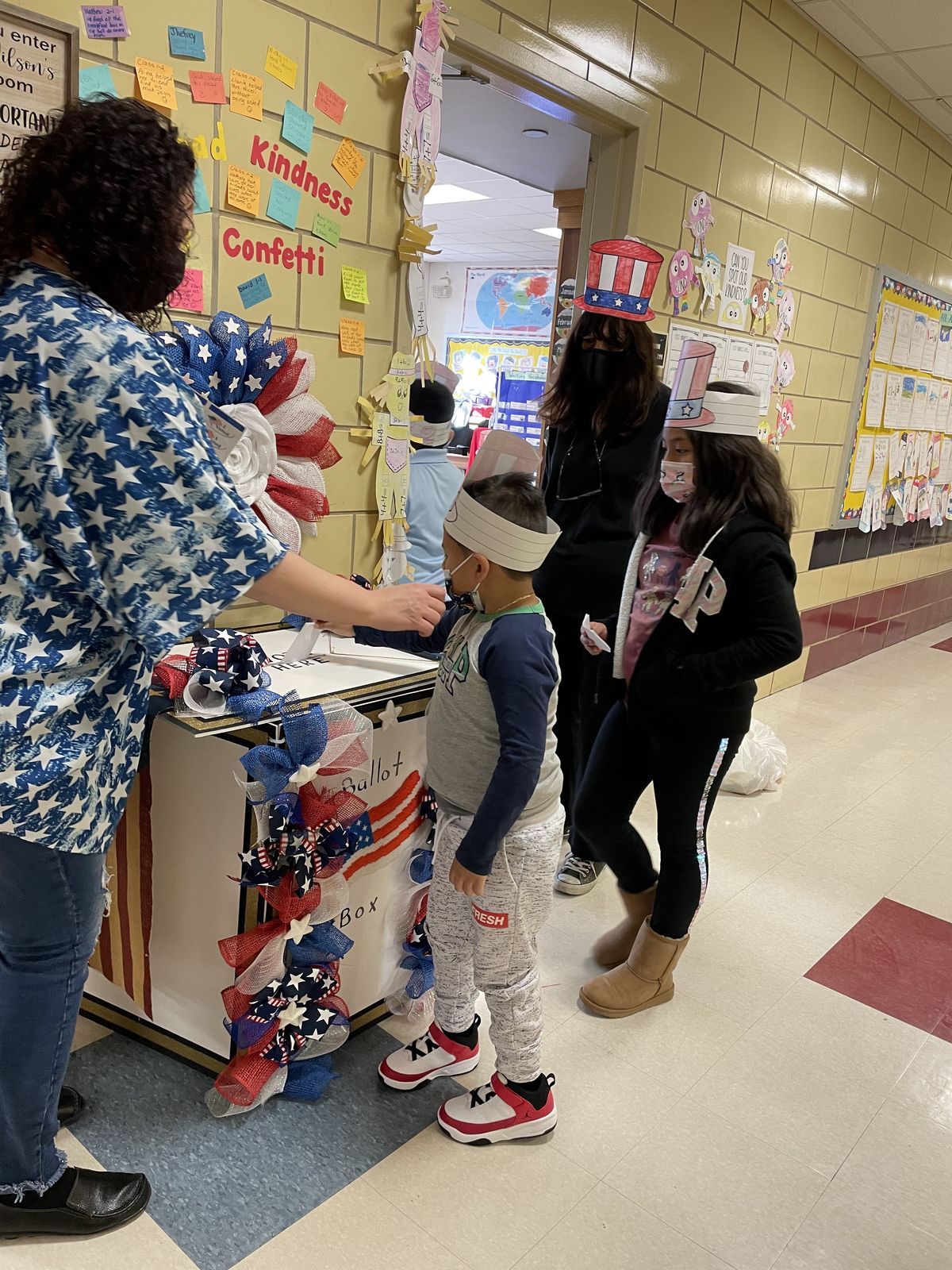 Teacher helping a student vote in the hallway