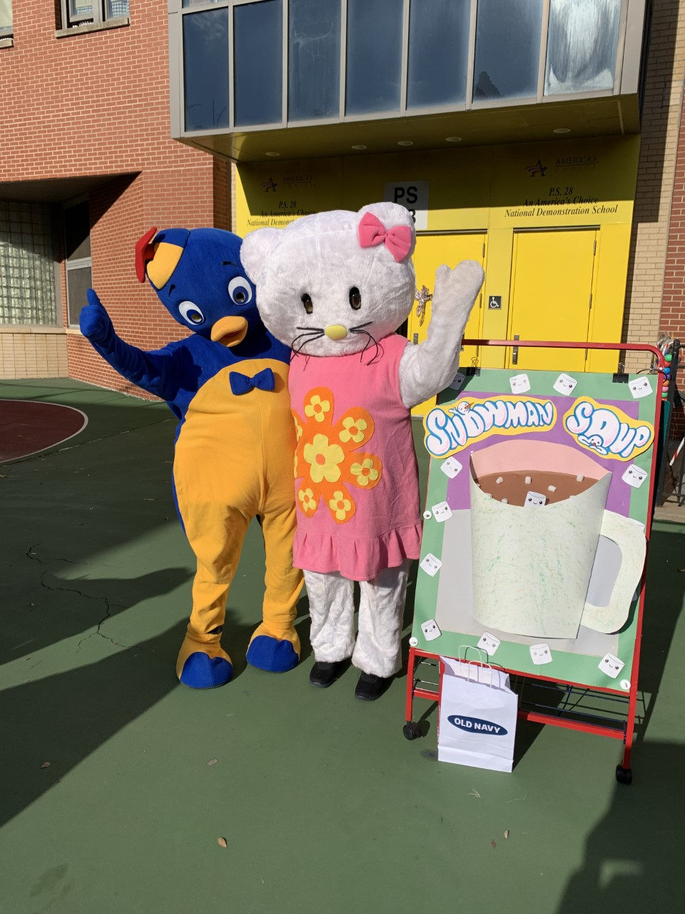 Costumed characters beside a Snowman Soup display in the schoolyard