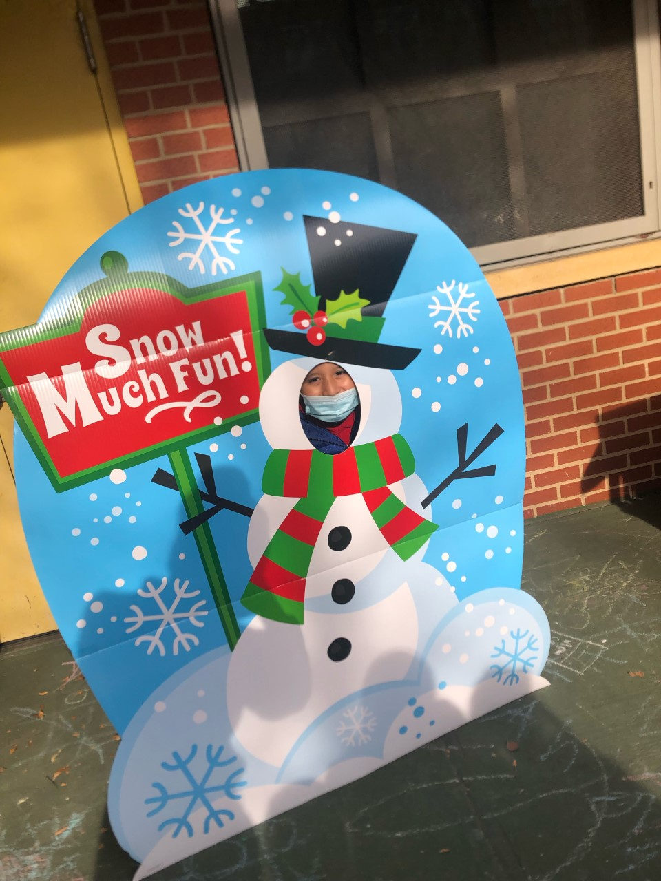 Student posing in the Snow Much Fun snowman cutout