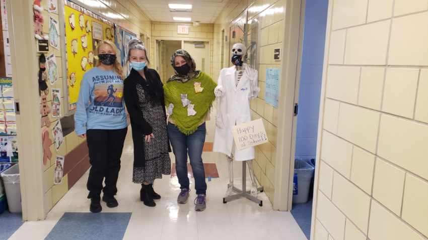 Staff members dressed up for the 100th day of school in the hallway