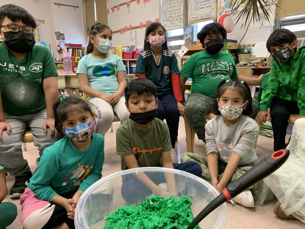 Students in green gathered around a bowl of green eggs