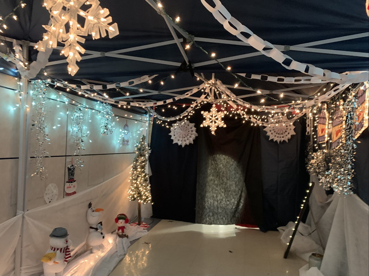 Holiday tent hung with string lights and paper snowflakes