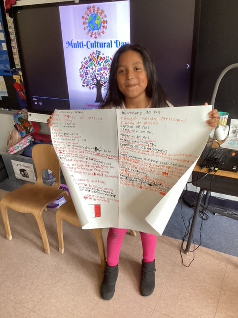 Student holding up a written country report on Multicultural Day