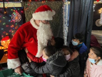 Santa visiting with students in a decorated holiday booth