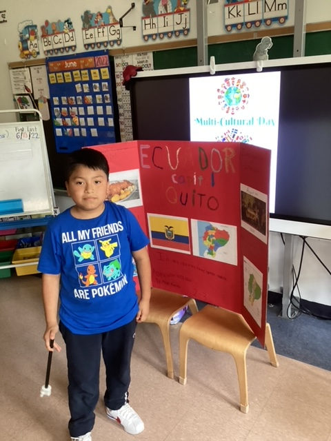 Student standing beside an Ecuador trifold board