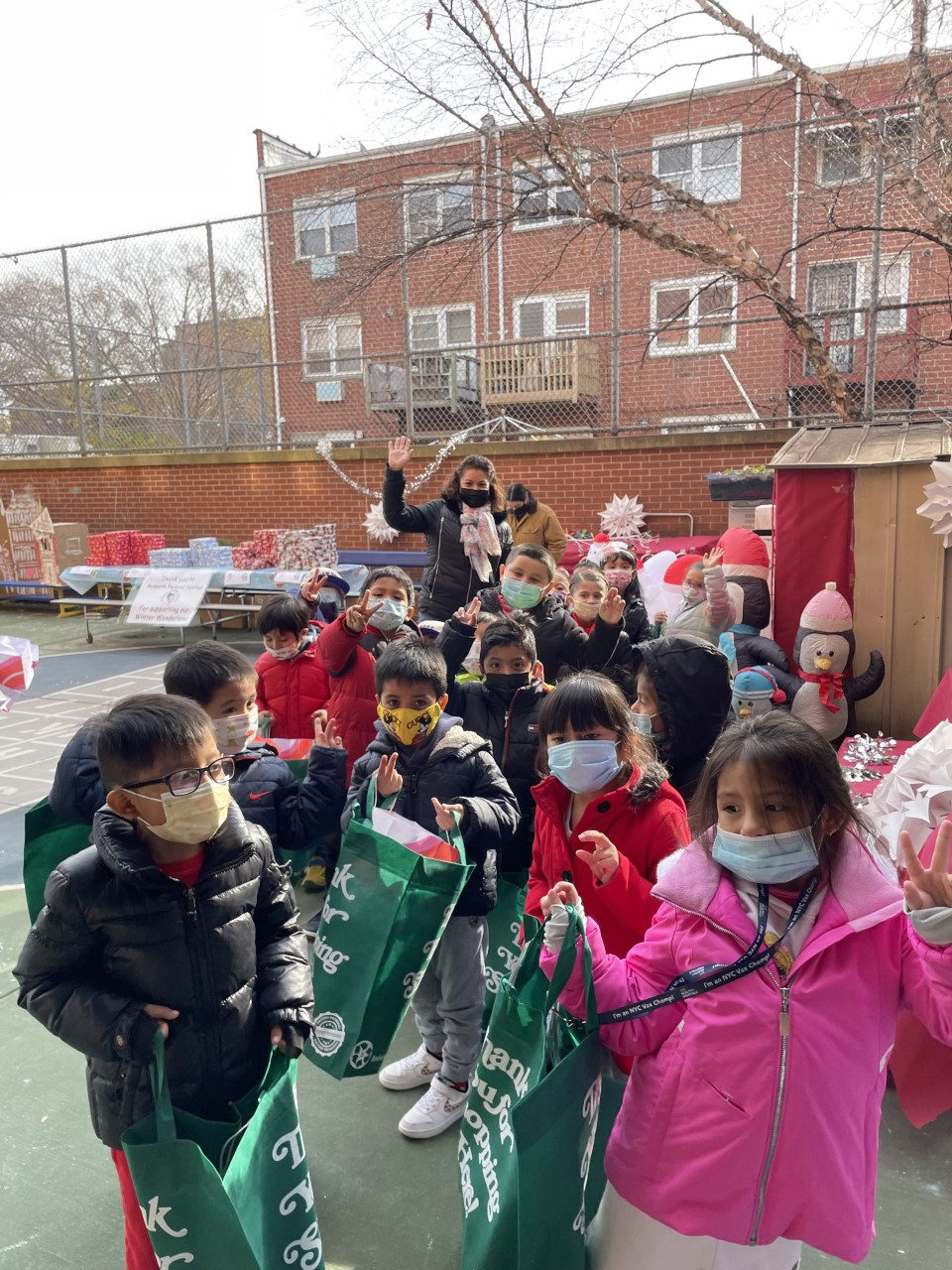 Students walking through the schoolyard with gift bags