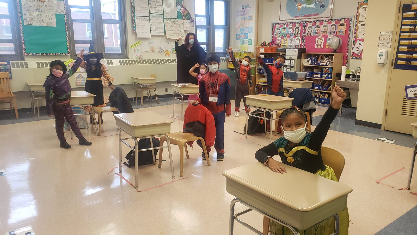 Students in superhero costumes at their desks