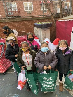 Students holding green Thank You for Shopping bags outdoors