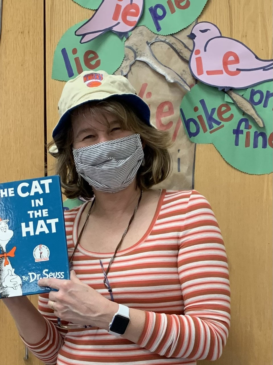 Teacher holding a copy of The Cat in the Hat