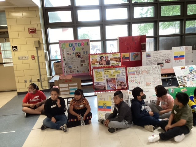 Students sitting on the floor in front of the country project displays