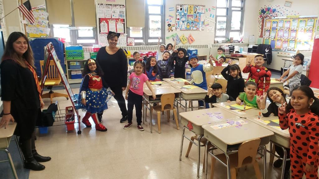 Students in costumes including a superhero in their classroom