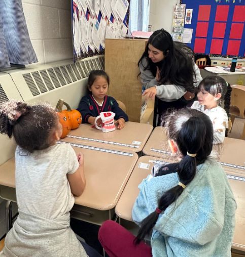 Students working at their desks with a visitor