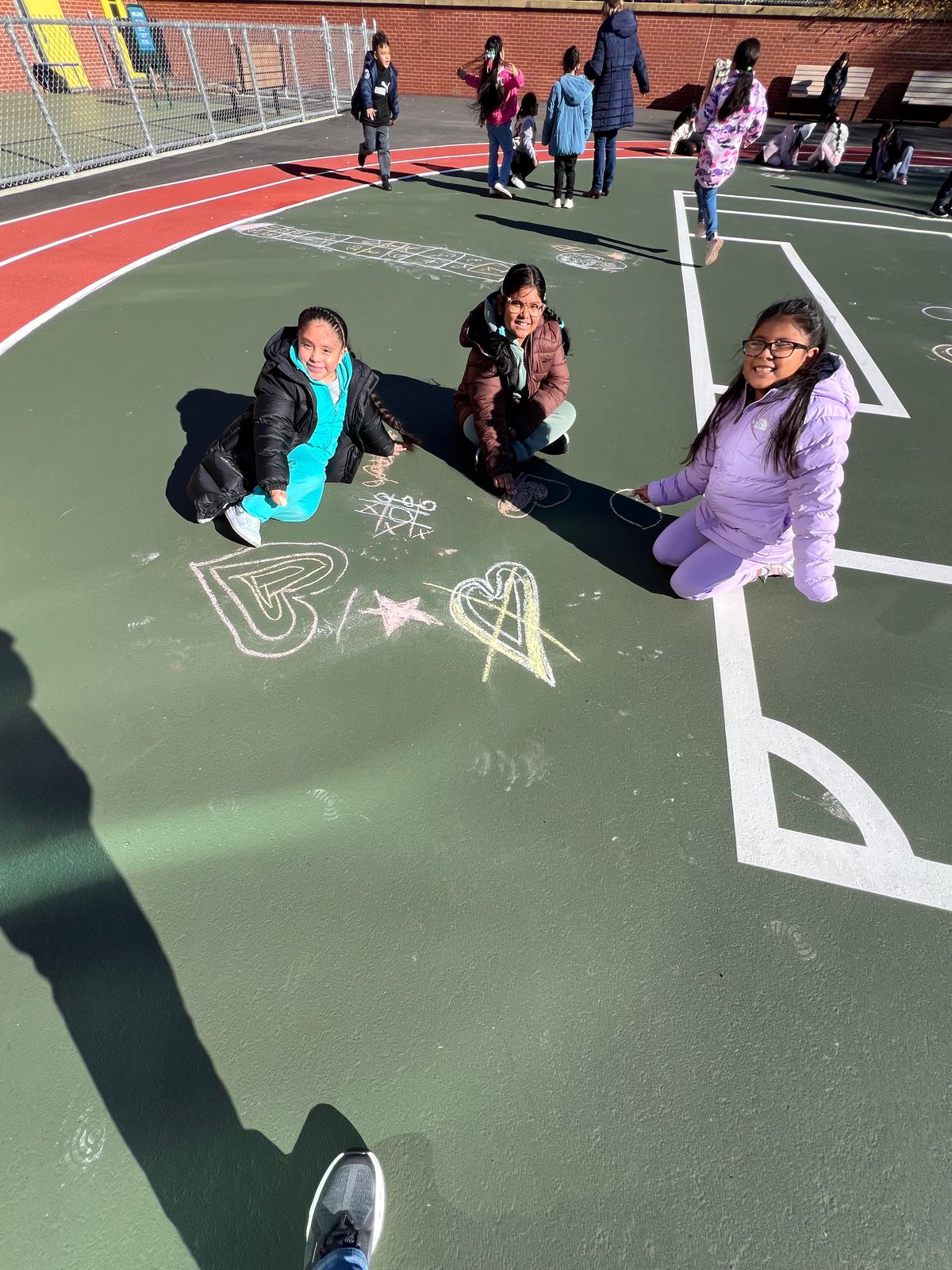 Students drawing with chalk on the schoolyard