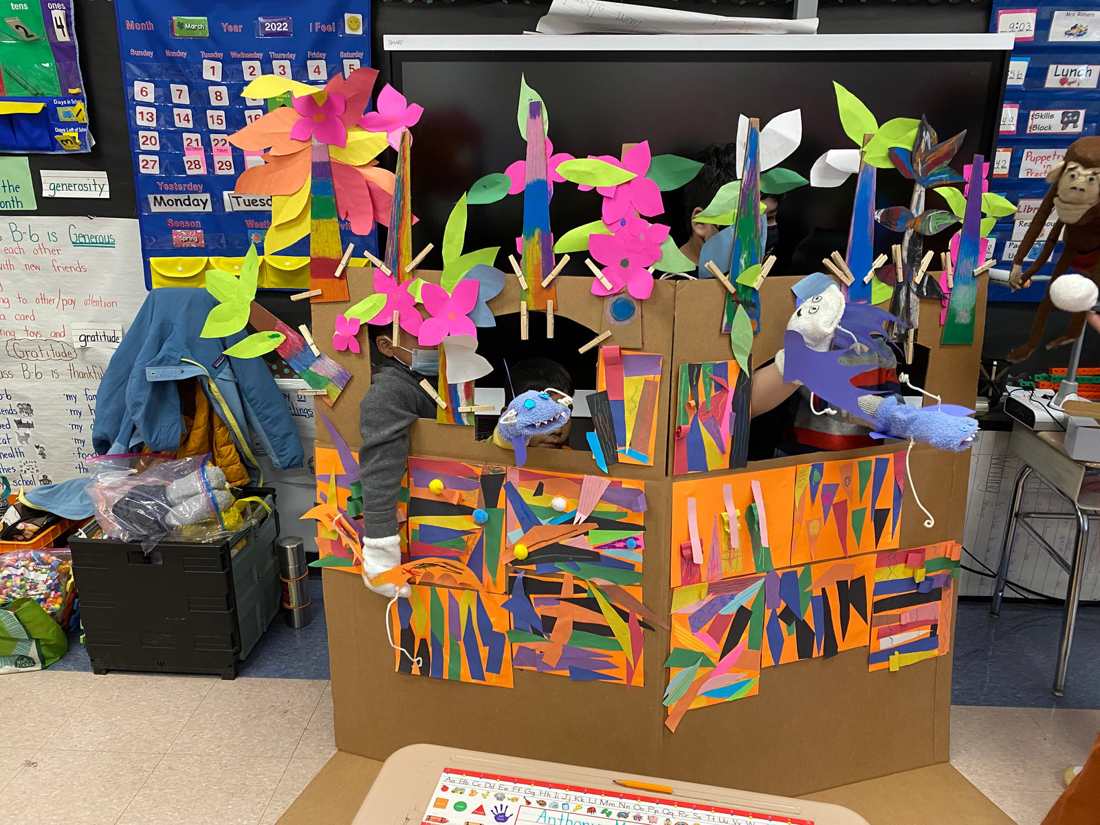 The finished puppet stage, covered in bright paper shapes and paper flowers