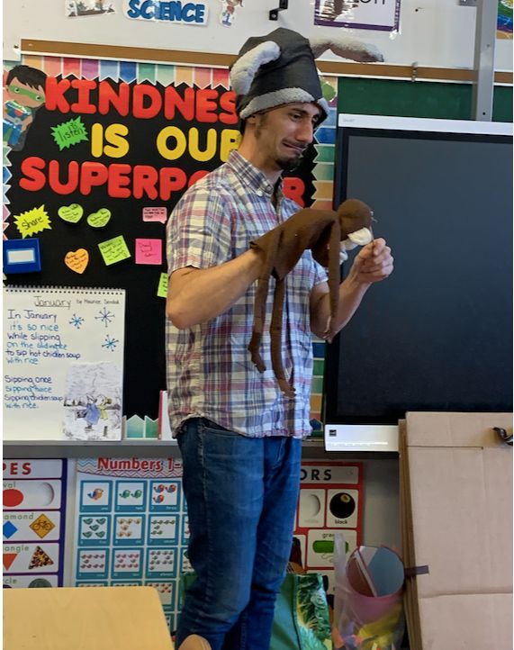 A Puppetry in Practice teaching artist performs with a monkey puppet in a P.S. 28 classroom