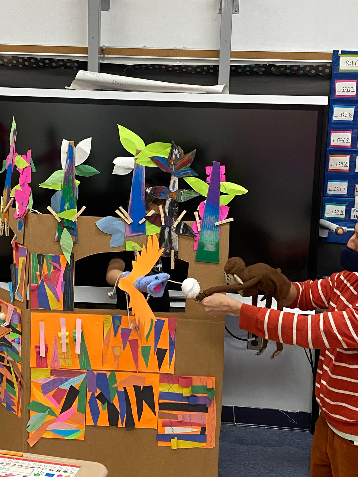Puppets appear in the window of the class puppet stage during a performance
