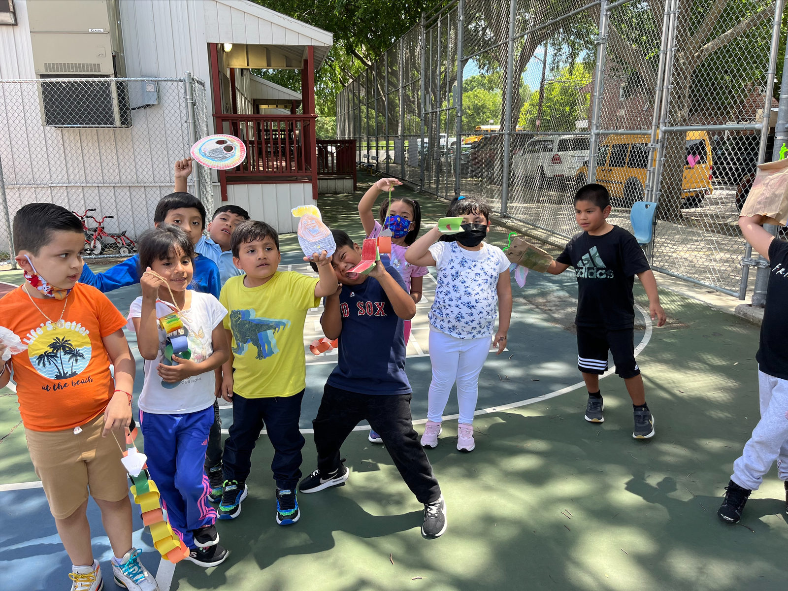 Students show their handmade puppets in the play yard
