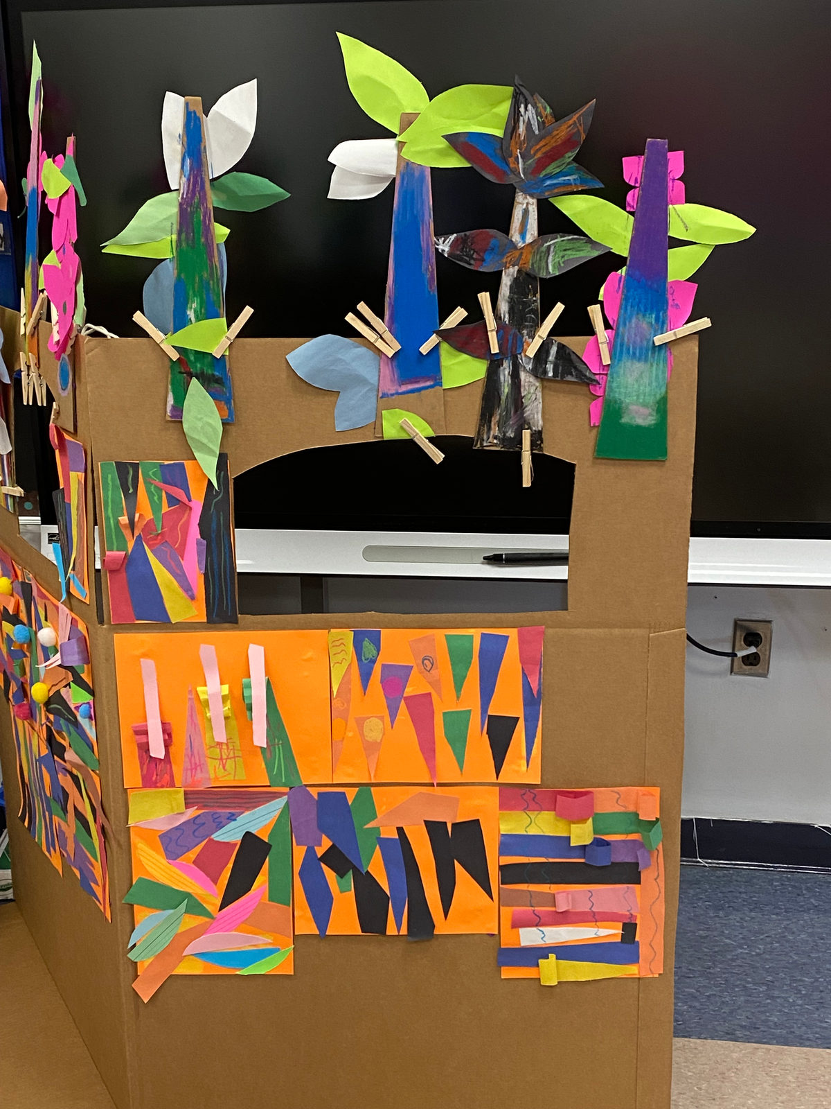 The class puppet stage, decorated with paper leaves and flowers, ready for a show